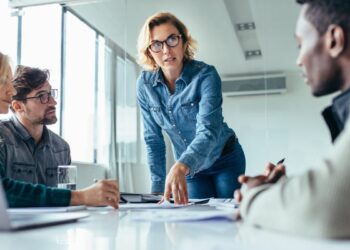 Businesswoman standing and leading business presentation. Female executive putting her ideas during presentation in conference room.