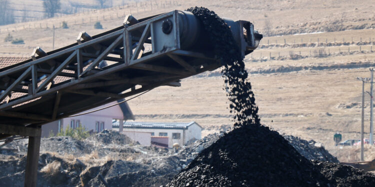Coal falling from the moving belt conveyor into the big pile, at the coal mine