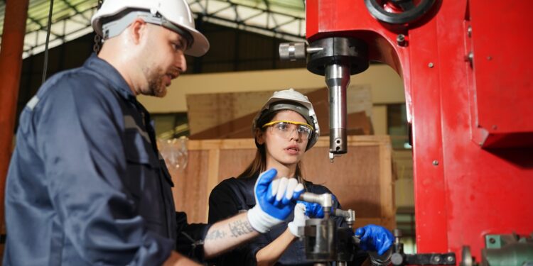Robotics engineer working on maintenance of modern robotic arm in factory warehouse(Multiple values)
